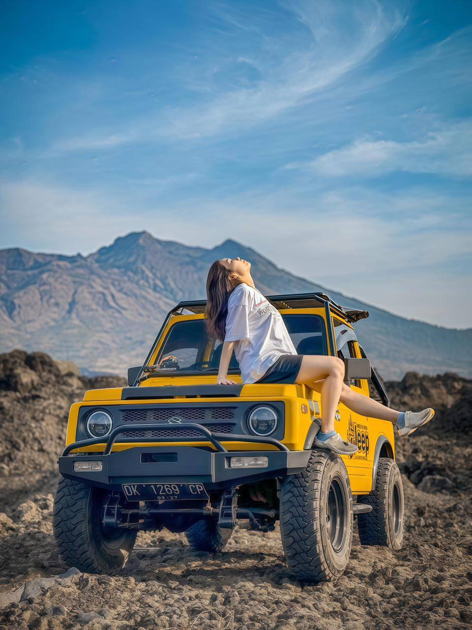 Yellow jeep overlooking the volcanic landscape