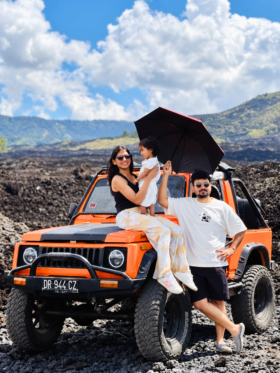 Family with an orange jeep in the Black Lava landscape